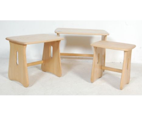 A contemporary Ercol furniture nest of graduating tables of rectangular form with pierced and shaped supports and elm tops to