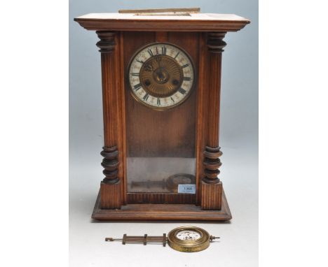 An early 20th century Edwardian wall Vienna Regulator clock of small proportaions having a brass and white enamel clock face 