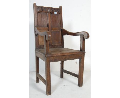 An 18th century&nbsp; oak Wainscot chair / armchair. The peg jointed carved top rail having concentric arch detailing above a