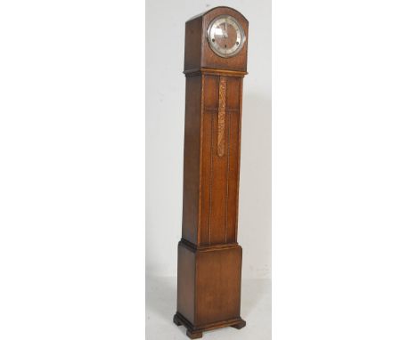 An Art Deco 1930's oak grandmother clock. The Art Deco case having a silvered chapter ring to the face and inset eight days b