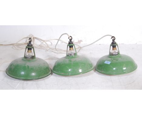 A collection of three vintage retro 20th century factory industrial green enamel UFO ceiling lights with conical shades, pier