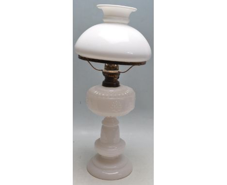 An early 20th century white milk glass table / oil lamp. The white glass body and reservoir with half moon matching white gla