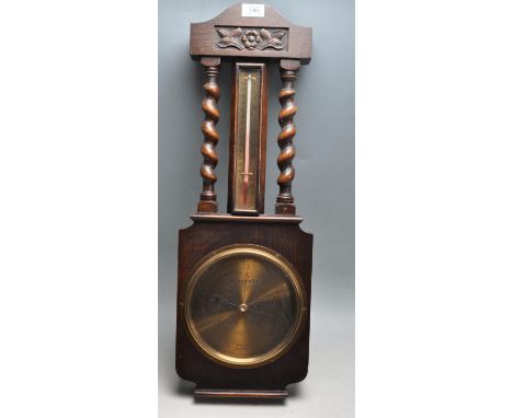 An early 20th century circa 1930’s oak cased aneroid banjo shape barometer by James Howell &amp; Co LTD having brass face wit