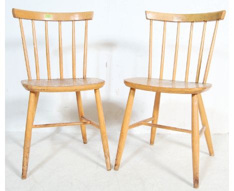 Two vintage 20th century beech and elm Ercol style dining chairs having spindle backrest with curved rail, panel seats raised