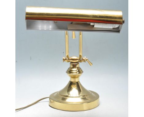 A 20th Century vintage bankers desk / table lamp light of brass construction having an adjustable brass  shade supported by t