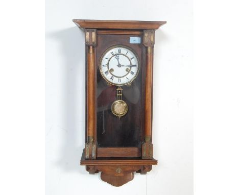 An early 20th century eight day mahogany cased Vienna style regulator wall clock having a pediment top over white enamel cloc