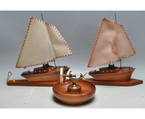 A pair of vintage retro teak wood table lamps in the form of boats with faux leather shades together with a wooden nautical n