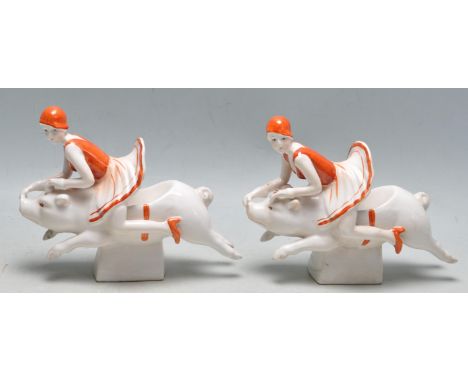 A pair of vintage style Art Deco revival ceramic bookends having two flapper girls riding pigs. The bookends have a cream bac