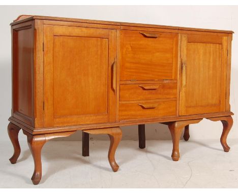 A vintage mid century light oak sideboard credenza / dinks cabinet having central drop front door over a bank of two drawers 