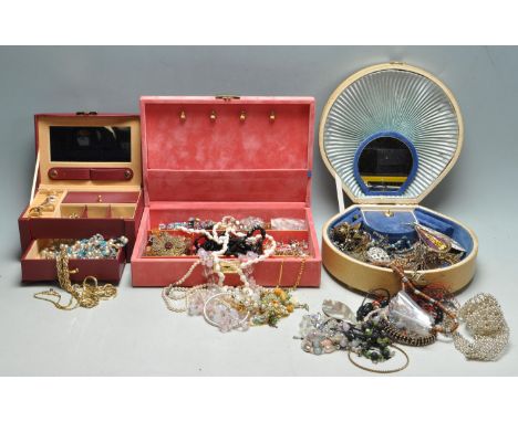 A collection of vintage costume jewellery over three boxes to include yellow metal and white metal rings, necklaces, pendants