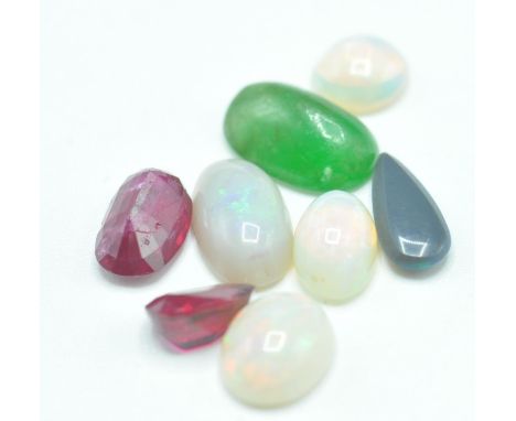 A collection of loose gemstones to include five opal cabochons of various shapes, two faceted rubies and a hard stone cabocho