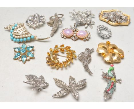 A collection of various mid Century vintage brooches to include an enamelled peacock brooch, various white metal marcasite se