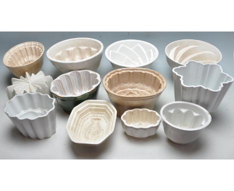 A collection of twelve 19th century and other ceramic jelly / pudding moulds in green, white and grey having impressed decora