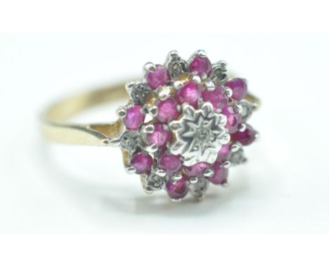 A 9ct gold cluster ring set with round cut ruby and diamonds. Assay marked for Birmingham. Weight 2.9g. Size M.5.