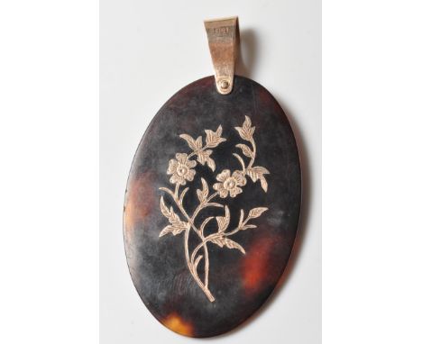 A 19th Century Victorian pique work pendant having an oval tortoiseshell panel decorated with a floral bouquet with a 9ct gol