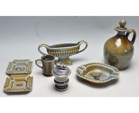 A collection of seven Irish porcelain items to include a Potten Jug with stopper, ashtray, table lighter, small cup. All with