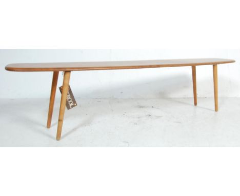 An 1970’s upcycled / repurposed beech and elm Ercol coffee table / bench of long rectangular form with plain top raised on tu