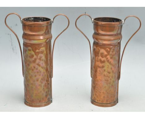 A pair of 19th century Victorian Art Nouveau style copper vases of a cylindrical form with twin handles and panel beated deco