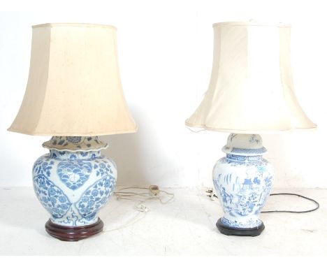 Two mid 20th century vintage Chinese blue and white&nbsp; bedside / table lamps raised on wooden carved stands. The lamps hav