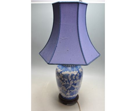 A 20th century antique style blue and white Chinese oriental table lamp of baluster form with blue fabric shade, blue foliate