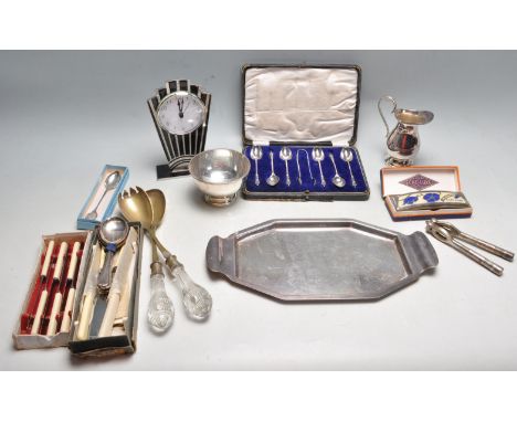 A collection of vintage 20th century silver plated items to include cutlery, tray knives, Art Deco style mantle clock, nutcra