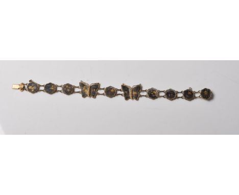 A vintage mid 20th century brass shakudo ten panel bracelet having two butterflies to the centre. Each panel has a black back