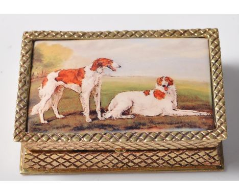 An 18ct yellow gold plated pill / snuff box with a hinged lid set with an enamel panel of hunting dogs. The pill box has a hi