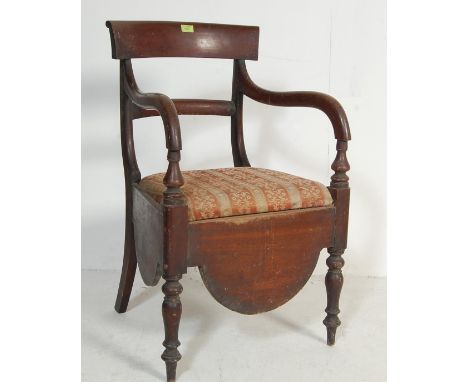 A 19th century antique Victorian mahogany commode chair. The chair having a panel backrest with curved elbow supports flankin