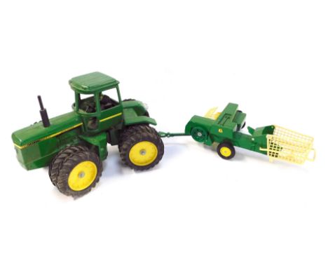 An Ertl John Deere diecast tractor, and a 585 baler. (2) 