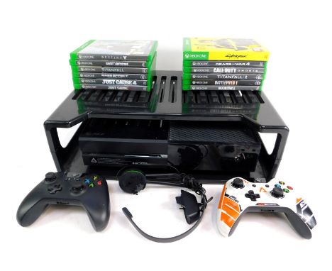 An Xbox one, in black with storage shelf, two controllers and various games to include Cyberpunk, 2077, Titan 42, Call of Dut