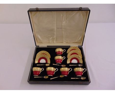 An Aynsley cased set of coffee cups and saucers to include six silver and enamel teaspoons (six cups, five saucers)