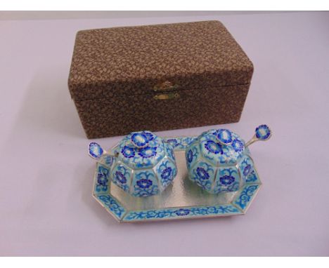 A cased set of Korean white metal and enamel condiments to include a tray, two covered dishes and two condiment spoons