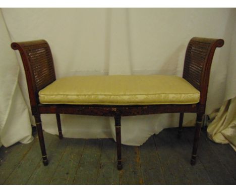 An Edwardian rectangular two seater Sheraton style love seat with scroll sides, bergere seat, on four turned cylindrical legs