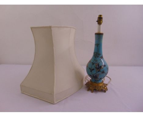 A porcelain pear shaped table lamp with gilded metal mounts decorated with flowers, leaves and birds to include silk shade