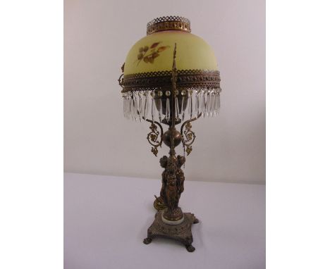 A Victorian brass table lamp, figural stem on shaped square base with frosted glass shade and drop lustres