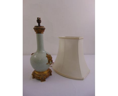A Chinese style baluster form table lamp with gilded metal mounts to include silk shade