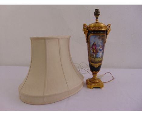 A porcelain tapering cylindrical table lamp with gilded metal mounts decorated with eighteenth century style courtly scenes a