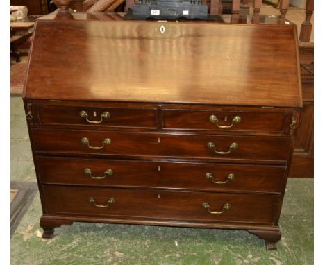 A George III mahogany bureau, fall front enclosing a satinwood veneered arrangement of pigeon holes and small drawers centred