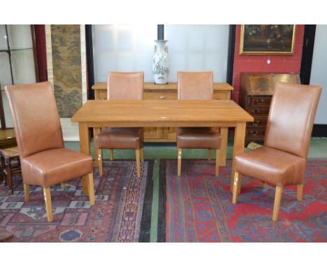 A modern light oak dining table and four leather upholstered dining chairs.