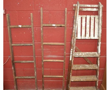 A wooden vintage step ladder and two short wooden ladders