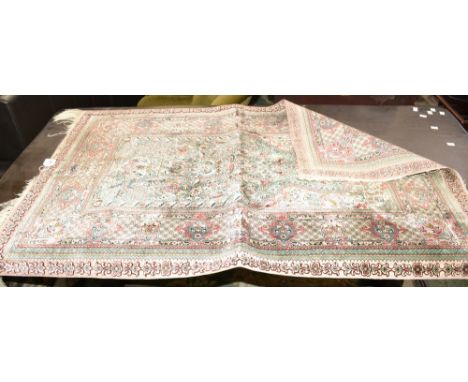 A Middle Eastern rectangular silk carpet, the rug centre colourfully embroidered with a double-bowed scrolling cartouche of f