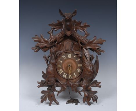 A German Black Forest cuckoo clock, 14cm dial with Roman numerals, the case carved  stags head and hanging game, 49cm high, c