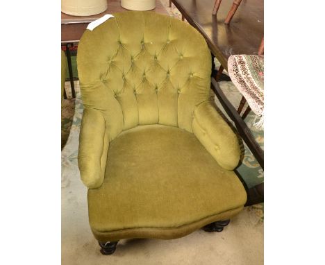 A Victorian ebonised nursing chair, button upholstered back, stuffed overseat, turned forelegs, ceramic casters, circa 1860.