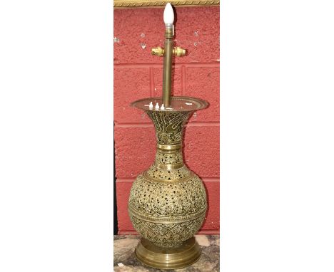 A large Indian pierced brass baluster lamp. decorated with scrolling flowers 