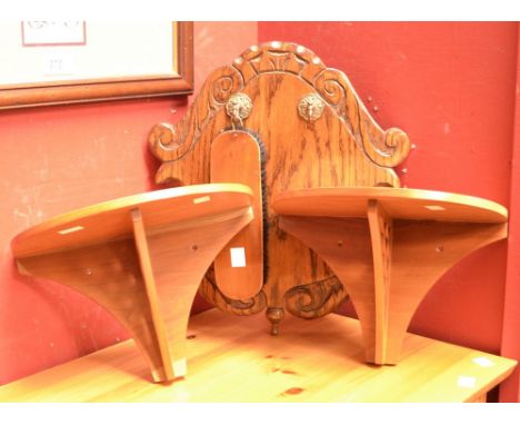 A pair of demi-lune wall brackets, pierced fretwork supports; a carved oak shield shaped hall bracket with hanging hooks, one