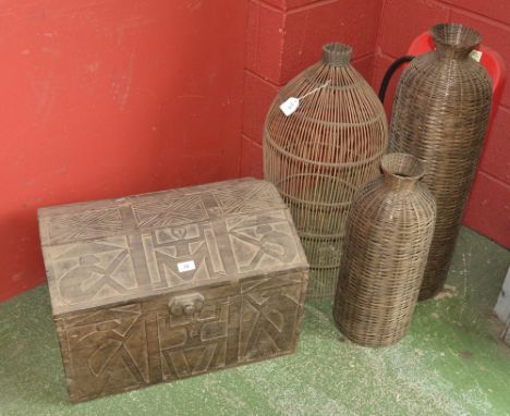 A modern Indonesian trunk with figural carved panels; three wickerwork cages. (4)