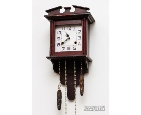 A wall clock with pine cone form hanging weights, square white enamel dial 