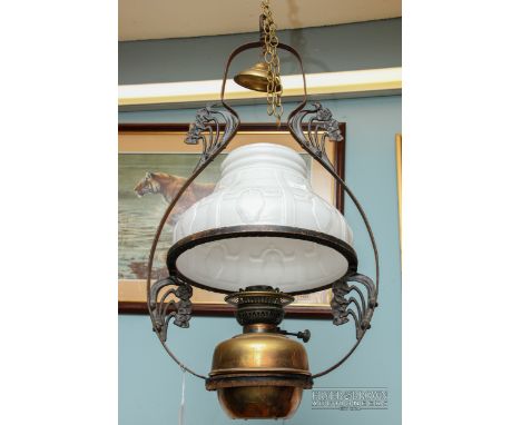 A hanging oil lamp, with brass reserve, wrought iron frame and white glass shade 