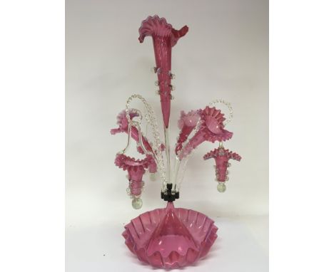An exceptional Victorian opaque and cranberry glass epergne with hanging baskets and three trumpet flutes with shaped edges n