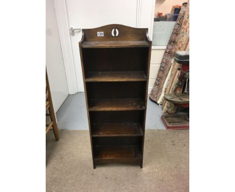 An open shelf bookcase and a vintage trunk with key.